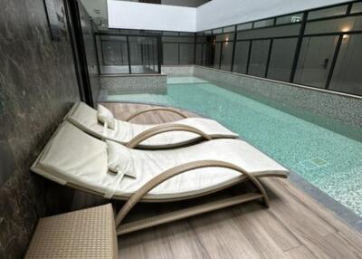 Indoor pool area with lounge chairs