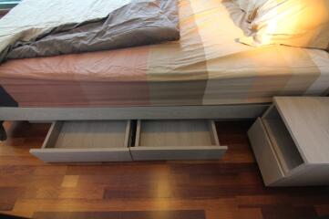 Bedroom with wooden drawers under the bed