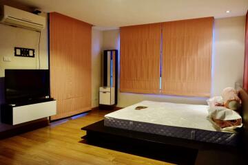 Bedroom with bed, TV, air conditioner, and curtains