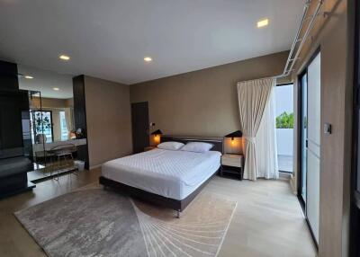 Spacious modern bedroom with king bed and balcony access