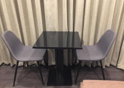 Two chairs and table in front of curtains