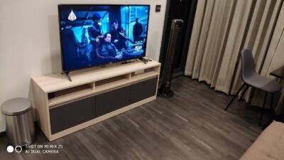 Living room with TV, wooden flooring, and modern furniture