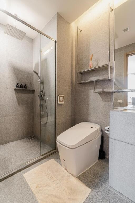 Modern bathroom with glass shower enclosure and smart toilet