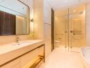 Modern bathroom with large mirror, sink, toilet, and shower area