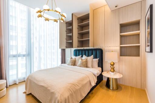 Beautifully decorated bedroom with natural light and built-in shelving