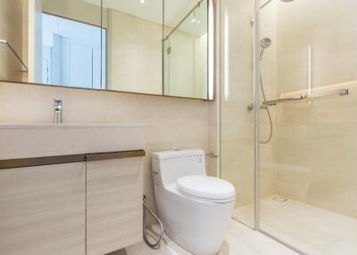 Modern bathroom with glass shower, toilet, and vanity