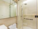 Modern bathroom with glass shower enclosure and wall-mounted toilet