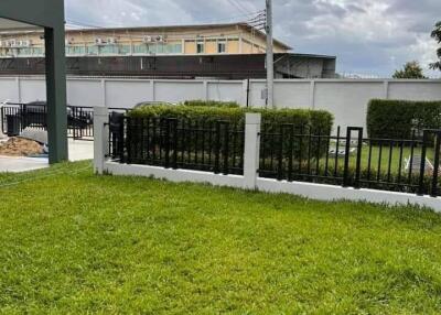 green lawn with fenced border and cloudy sky