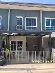 Front view of a modern townhouse with gated driveway