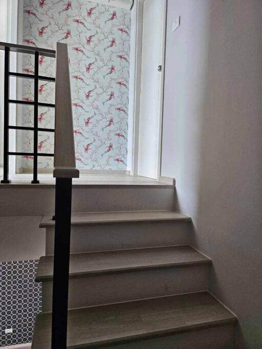 Interior stairway leading to upper floor with decorative wallpaper