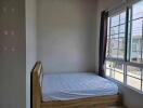 Bedroom with a wooden bed frame and large windows