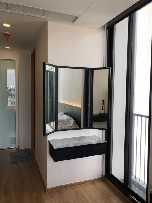 Modern bedroom with large window and wall-mounted dressing area