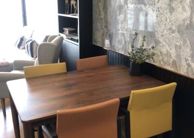 Dining table with chairs next to a wall and window