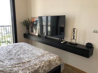 Modern bedroom with wall-mounted TV and artwork