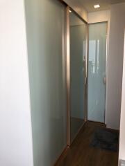 Modern corridor with frosted glass doors and hardwood flooring