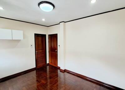 Empty bedroom with wooden floor and white walls