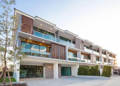 Modern multi-story residential building with large windows and balconies