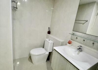 Modern bathroom with toilet, sink, and mirror