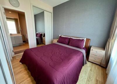 Bedroom with large bed, wooden flooring, and view into adjoining bathroom