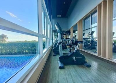 Modern gym area with exercise equipment and large windows overlooking a scenic view