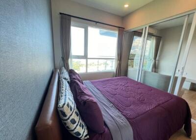 Bedroom with large window and glass door to balcony