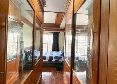 Narrow hallway with wooden panels and bedroom view