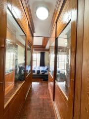 Narrow hallway with wooden panels and bedroom view