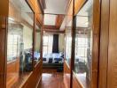 Narrow hallway with wooden panels and bedroom view