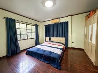 Spacious bedroom with large window, bed, and wardrobe