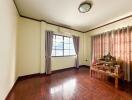 Spacious living room with a window and wooden flooring