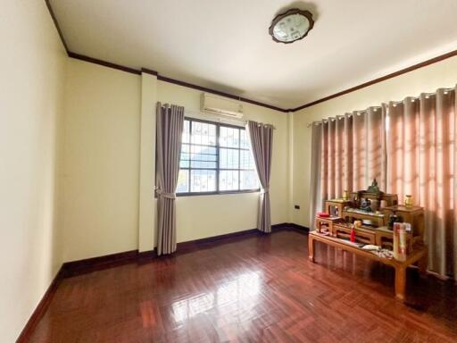 Spacious living room with a window and wooden flooring