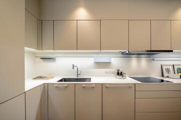 Modern kitchen with beige cabinets and under-cabinet lighting