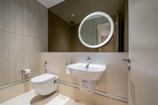 Modern bathroom with wall-mounted toilet and sink, large mirror, and wooden paneling