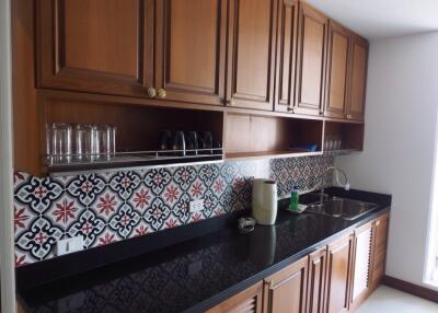 Spacious kitchen with wooden cabinets and patterned backsplash