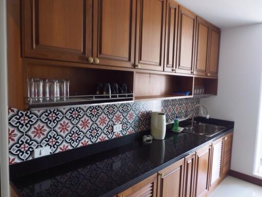 Spacious kitchen with wooden cabinets and patterned backsplash