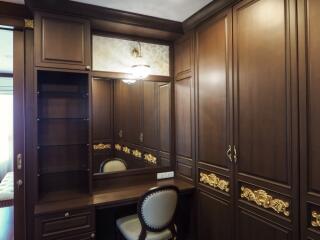 Elegant bedroom dressing area with wooden cabinetry and large mirror