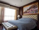 Bedroom with large bed, upholstered bench, and artwork