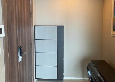 Modern entryway with wooden door, shoe storage, and side table