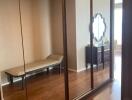 Bedroom with large mirrored wardrobe and chaise lounge