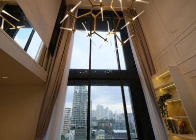 Modern living room with tall windows and unique chandelier