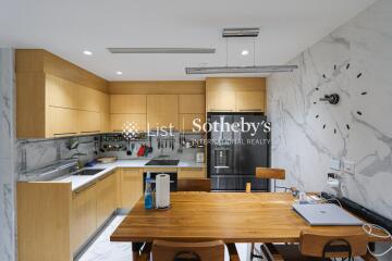 Modern kitchen with wooden cabinets and a dining area.