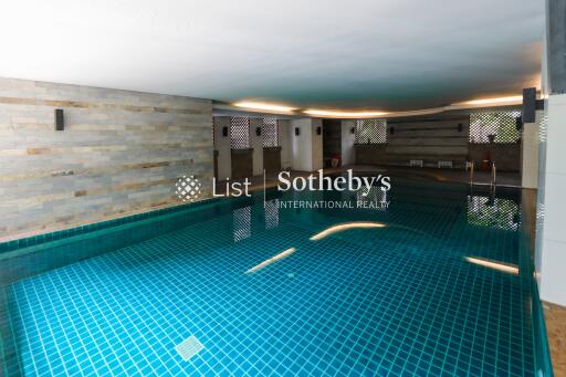 modern indoor swimming pool with tiled walls and ambient lighting