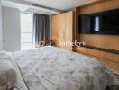 Spacious bedroom with large wardrobe and mounted TV