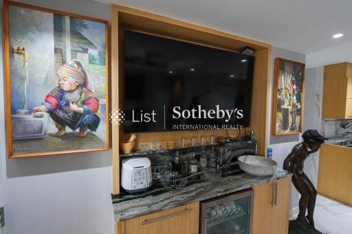 Living area with wall-mounted TV and artworks