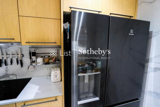 Modern kitchen with stainless steel refrigerator and wooden cabinets