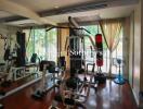 Well-equipped home gym with exercise equipment and large windows