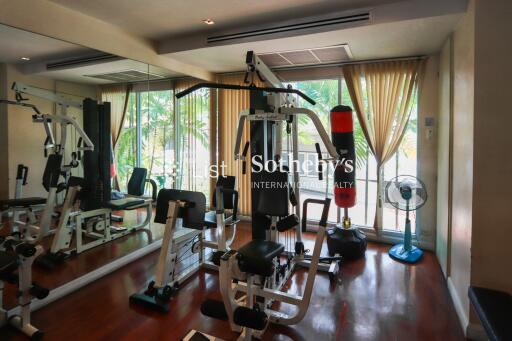 Well-equipped home gym with exercise equipment and large windows