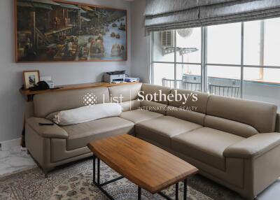 Modern living room with large beige sectional sofa and wooden coffee table