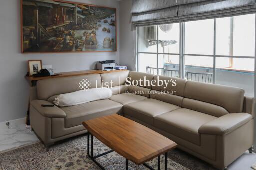 Modern living room with large beige sectional sofa and wooden coffee table