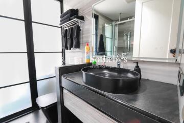 Modern bathroom with black countertop and round sink